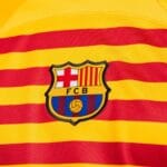 Quarta-maglia-Barcellona-2022-23-gialla-Nike-dettaglio-fc-barcelona-logo dettaglio del logo FCB Barcelona della Quarta maglia Barcellona 2022/23 Nike gialla